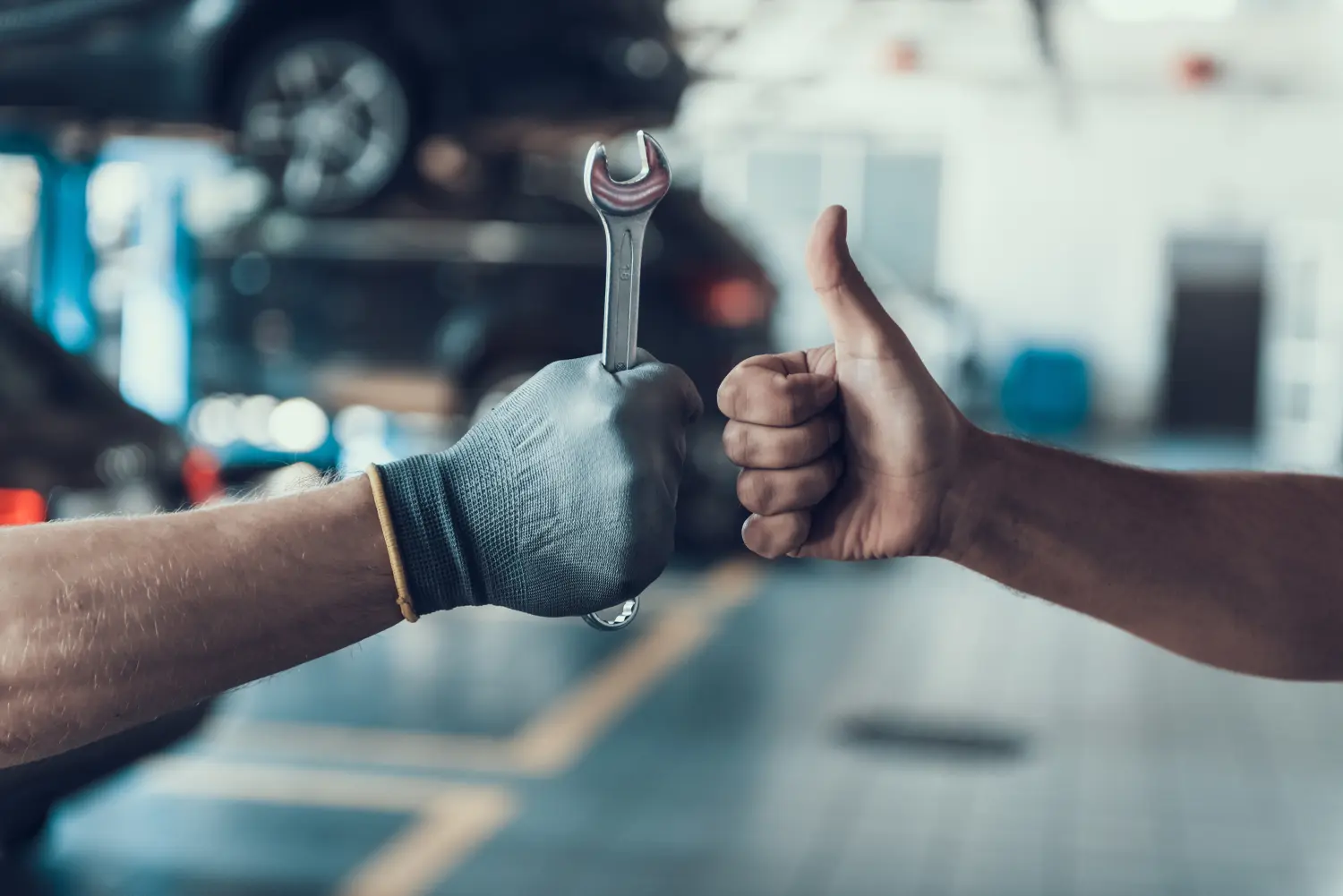 Nahaufnahme Daumen hoch und Mechaniker Hand mit Werkzeug